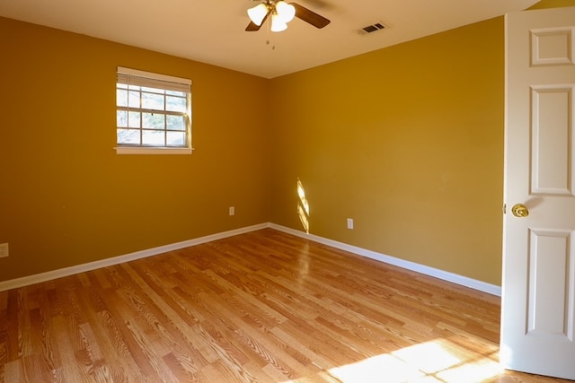 unfurnished room with visible vents, baseboards, light wood-style floors, and a ceiling fan