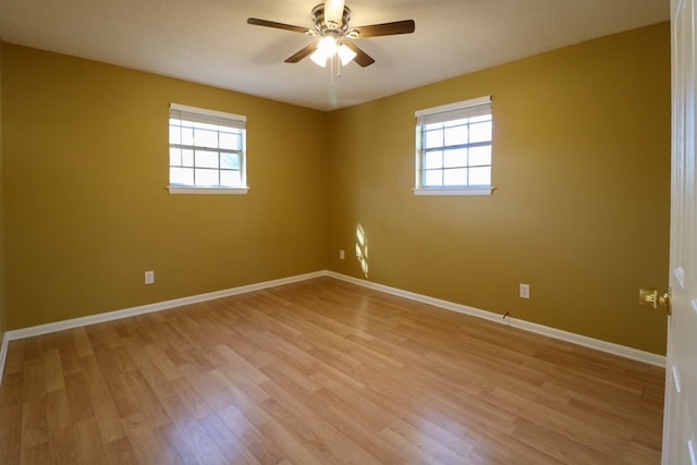 unfurnished room featuring a wealth of natural light, light wood-type flooring, and baseboards