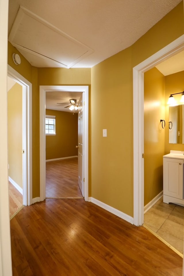 hallway featuring light wood-style floors and baseboards