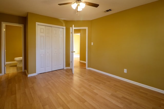 unfurnished bedroom featuring light wood-type flooring, visible vents, a closet, connected bathroom, and baseboards