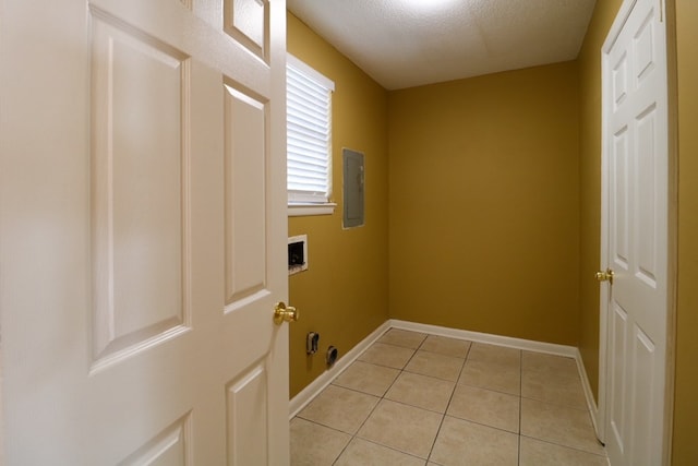 laundry area featuring washer hookup, electric panel, light tile patterned floors, baseboards, and laundry area