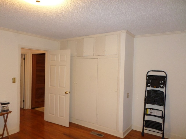 701 Collier St, Bainbridge, GA 39819 - bedroom featuring wood finished floors, a textured ceiling, a closet, and crown molding