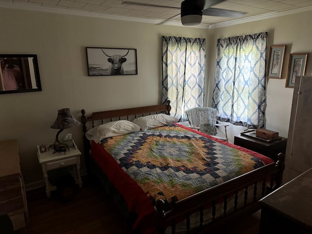 bedroom featuring dark hardwood / wood-style floors, ceiling fan, and ornamental molding