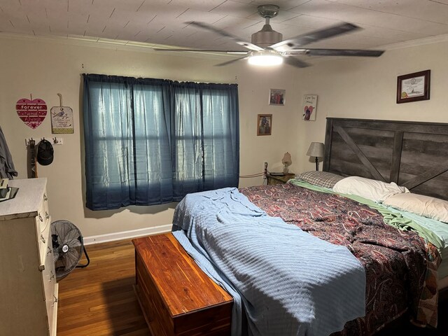 bedroom featuring ceiling fan, dark hardwood / wood-style floors, and ornamental molding