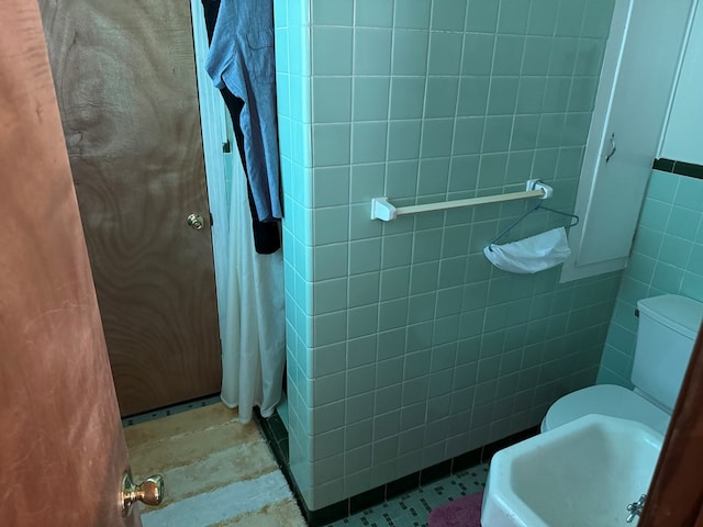 bathroom featuring sink and tile walls