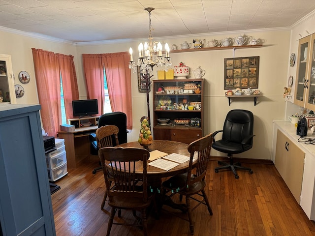 dining area featuring crown molding, a chandelier, and hardwood / wood-style flooring