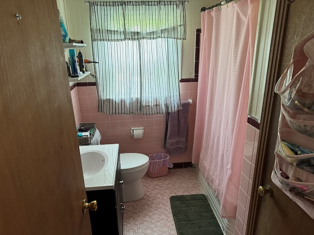 bathroom featuring a shower with curtain, vanity, toilet, and tile walls