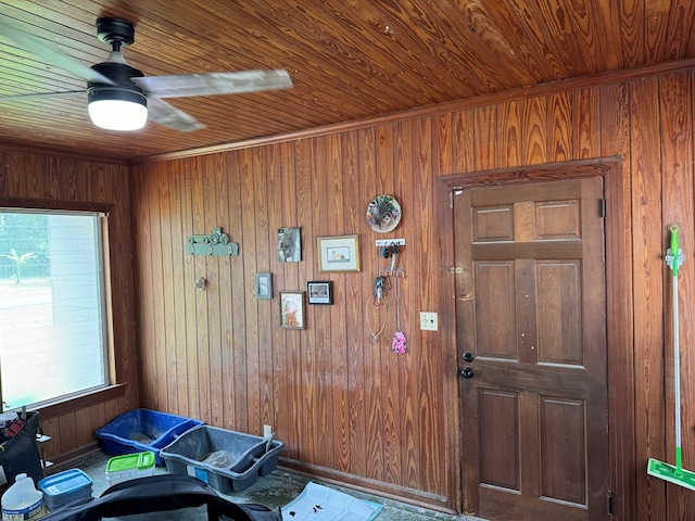 interior space featuring wood walls, ceiling fan, and wood ceiling