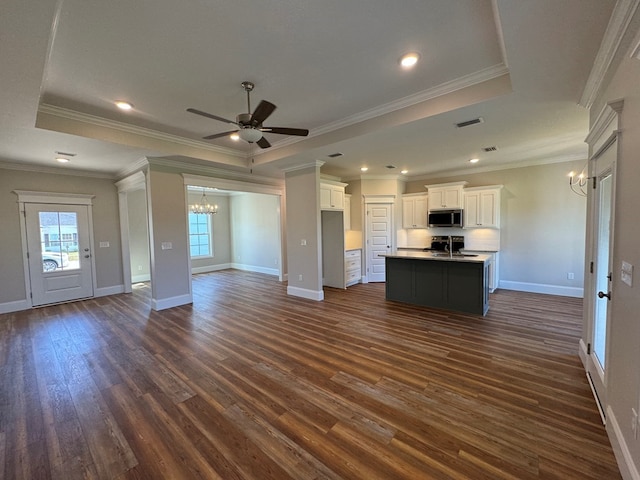 kitchen with ornamental molding, white cabinetry, a kitchen island with sink, and dark wood-type flooring