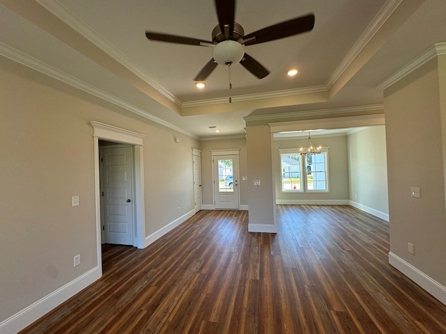 empty room featuring ceiling fan with notable chandelier, a raised ceiling, ornamental molding, and dark wood-type flooring