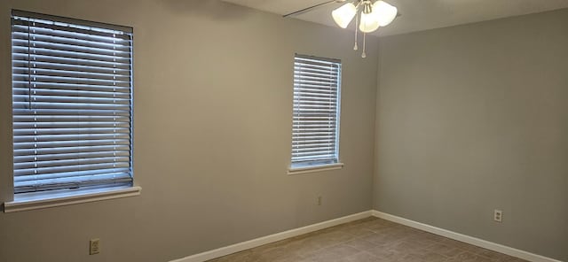 unfurnished room featuring baseboards and ceiling fan