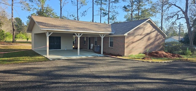 view of front facade featuring brick siding and a shingled roof