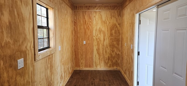 hallway with wooden walls and dark wood-style flooring