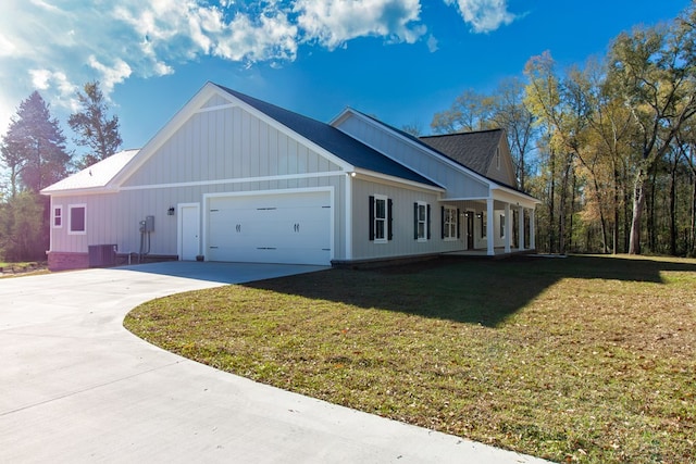 view of side of property featuring a lawn, a garage, central AC, and concrete driveway