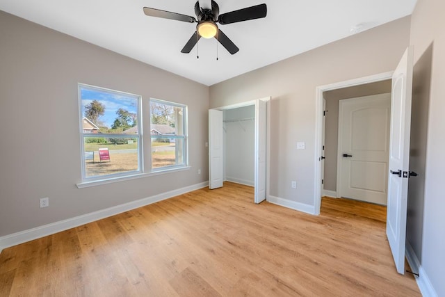 unfurnished bedroom featuring ceiling fan, light wood-style floors, a closet, and baseboards