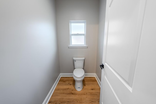 bathroom featuring toilet, baseboards, and wood finished floors