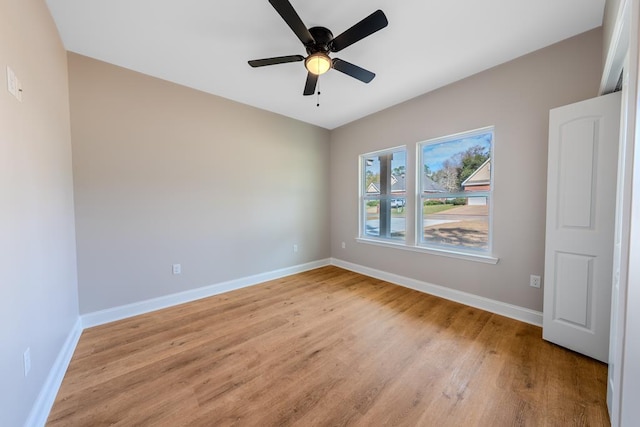 unfurnished room featuring a ceiling fan, light wood-type flooring, and baseboards