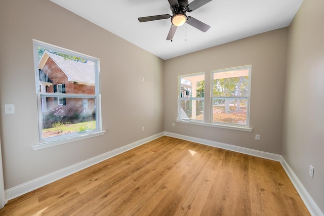 unfurnished room with light wood finished floors, a ceiling fan, and baseboards