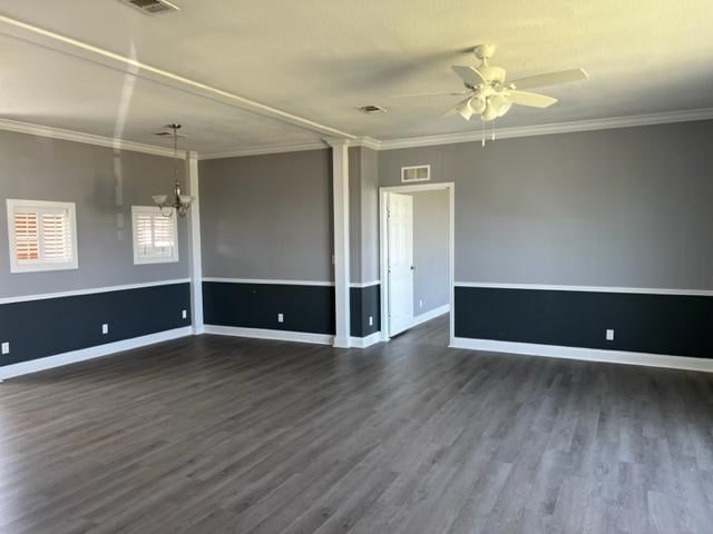 spare room with visible vents, dark wood-type flooring, and ornamental molding