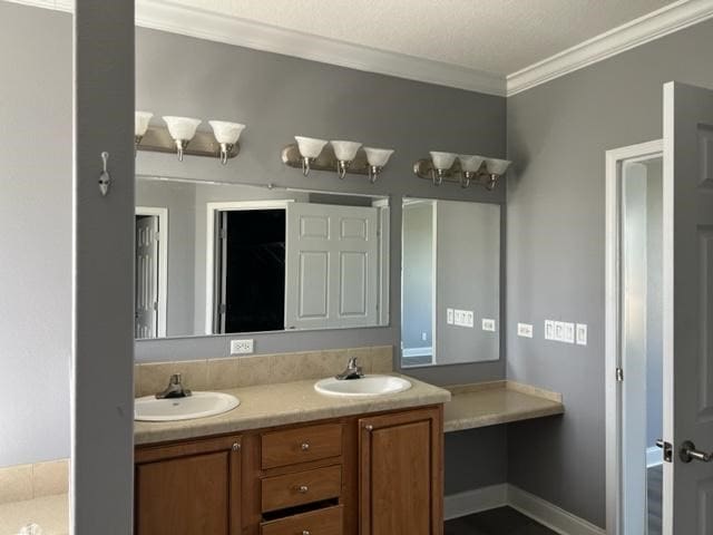 full bathroom featuring crown molding, a sink, baseboards, and double vanity