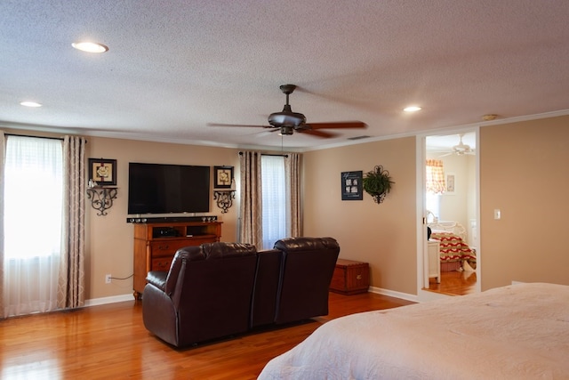 bedroom with baseboards, a textured ceiling, wood finished floors, and a ceiling fan