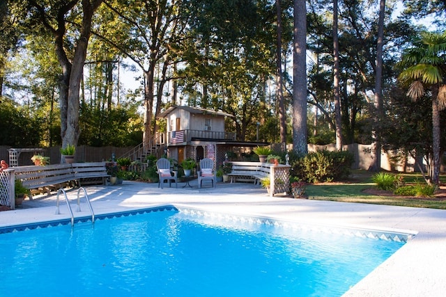 view of swimming pool with stairs, a fenced in pool, a patio area, and fence