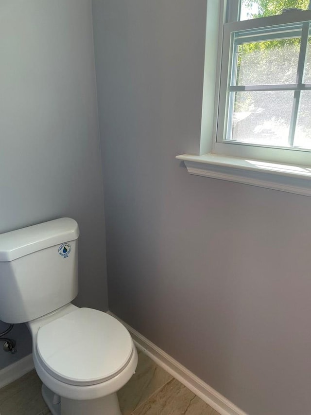 bathroom with toilet and baseboards