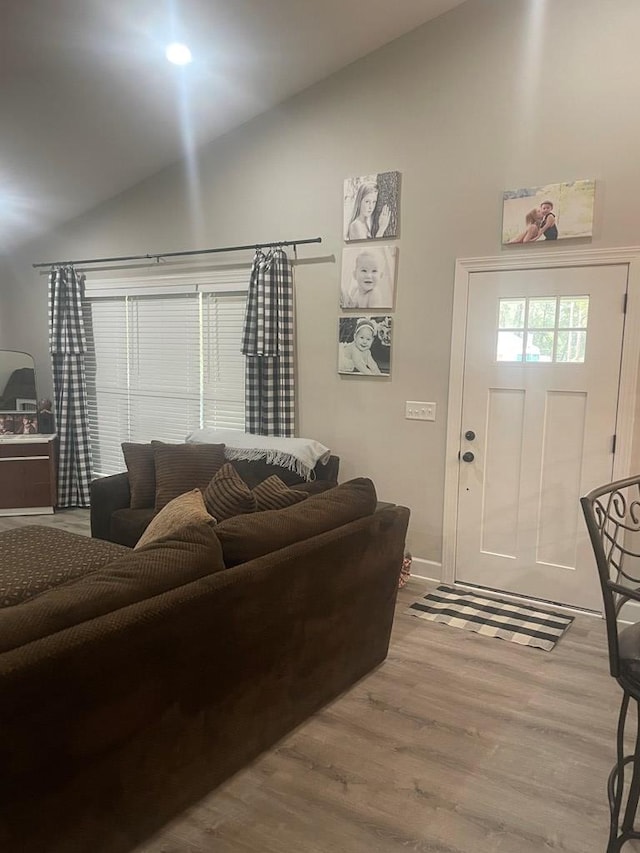 living area with high vaulted ceiling and wood finished floors