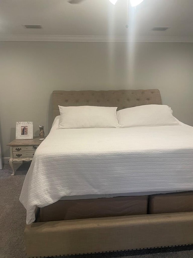 bedroom featuring crown molding, visible vents, and carpet floors