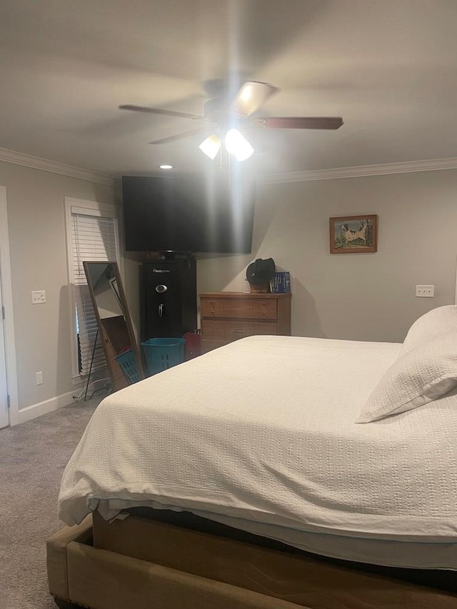 carpeted bedroom featuring ceiling fan, baseboards, and ornamental molding