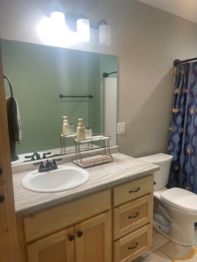 full bath with toilet, vanity, and tile patterned flooring