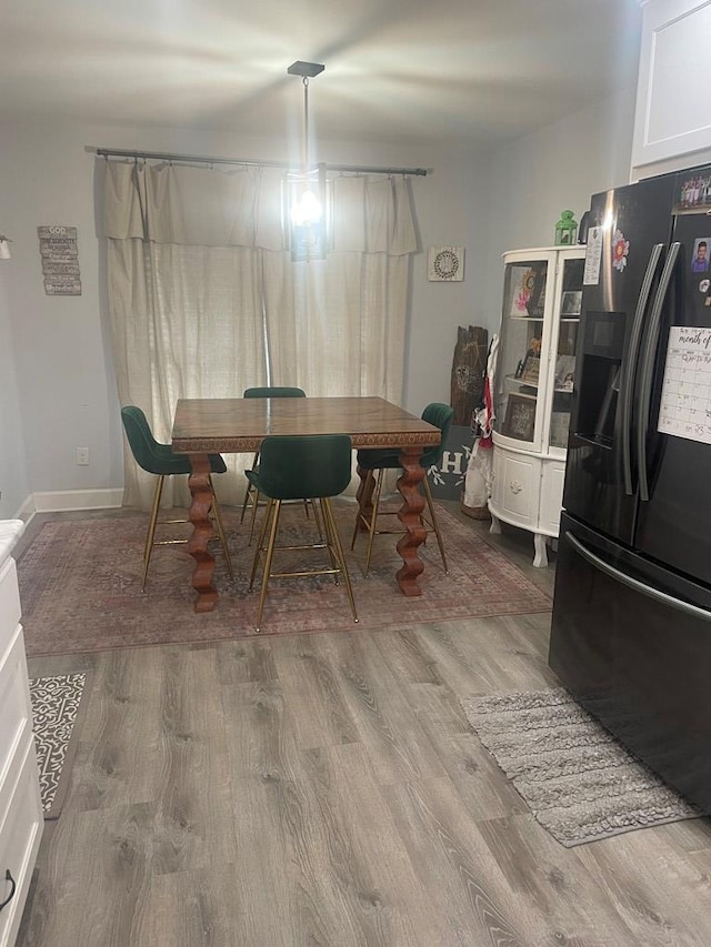 dining space with wood finished floors and baseboards