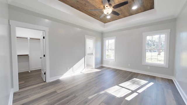 unfurnished bedroom with wood ceiling, ceiling fan, hardwood / wood-style floors, a raised ceiling, and a closet