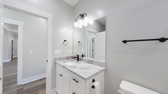 bathroom with vanity, toilet, and hardwood / wood-style floors