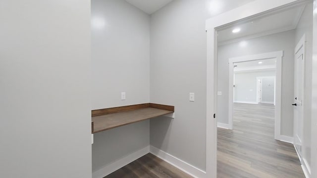 unfurnished office featuring hardwood / wood-style flooring and built in desk