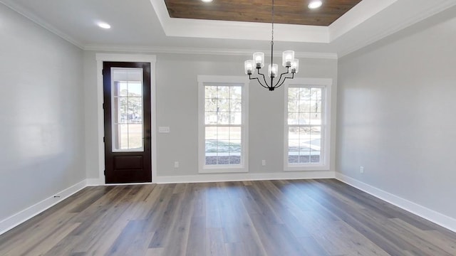 entryway featuring a raised ceiling, ornamental molding, dark hardwood / wood-style floors, and an inviting chandelier