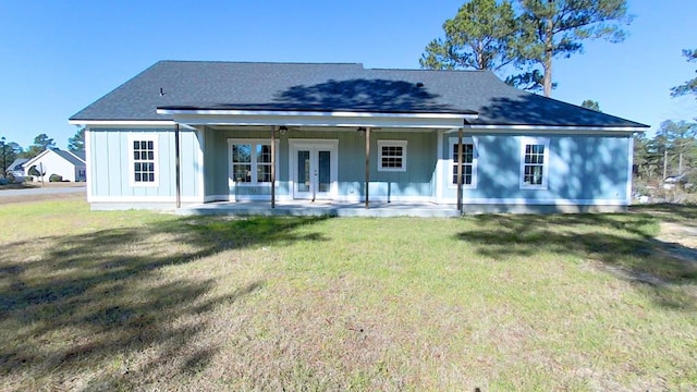 rear view of property featuring a yard, a patio area, and french doors