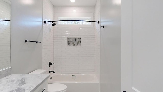 full bathroom with tiled shower / bath combo, vanity, and toilet