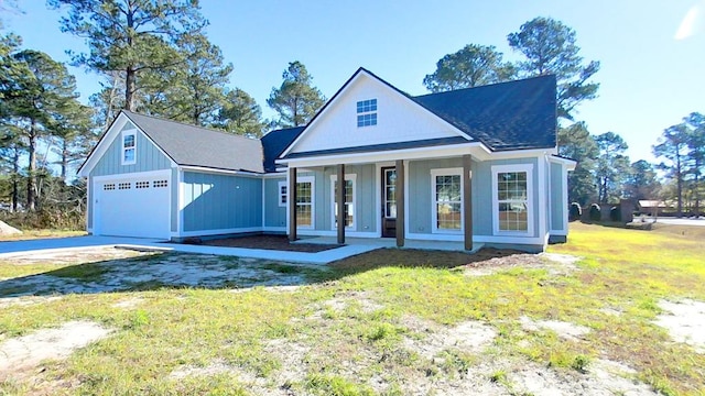 view of front of home with a garage, covered porch, and a front lawn