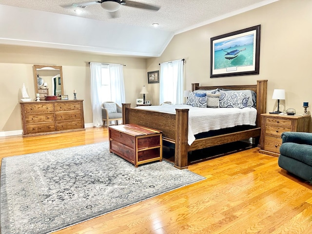 bedroom with a textured ceiling, ceiling fan, lofted ceiling, and hardwood / wood-style flooring