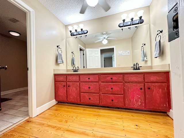 bathroom featuring hardwood / wood-style flooring, vanity, and a textured ceiling