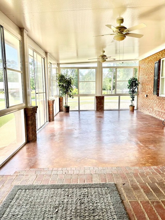 unfurnished sunroom featuring ceiling fan