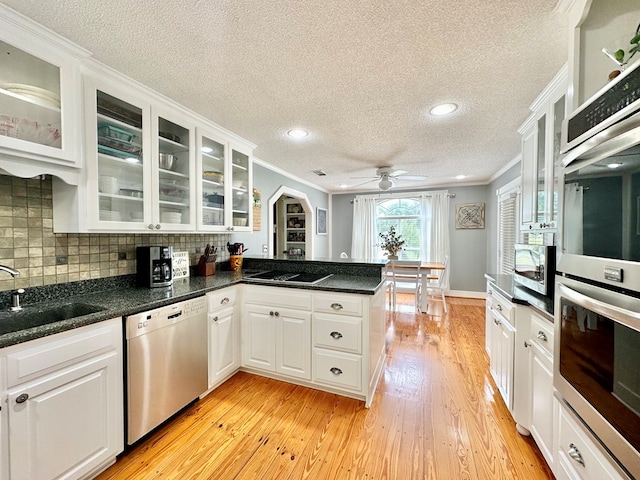 kitchen featuring white cabinets, sink, light wood-type flooring, and stainless steel appliances