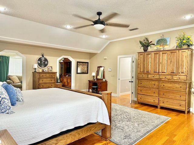 bedroom with ceiling fan, light hardwood / wood-style floors, a textured ceiling, and vaulted ceiling