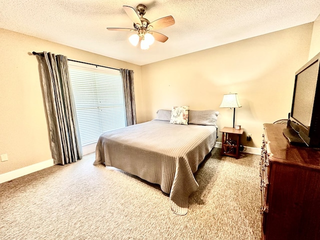 bedroom featuring ceiling fan, light colored carpet, and a textured ceiling