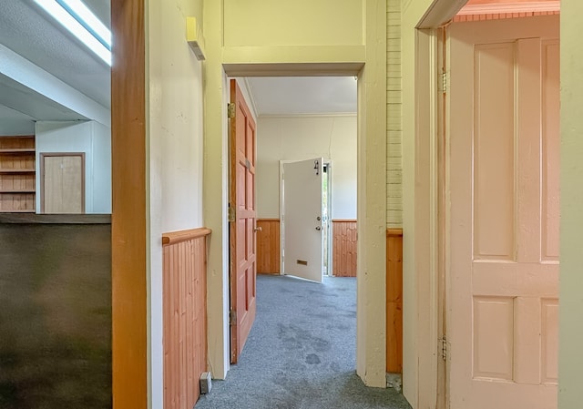 hall with wood walls and carpet