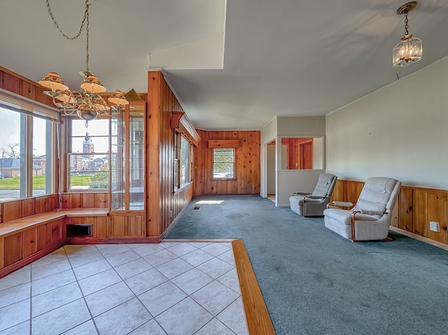 interior space featuring light carpet, an inviting chandelier, and wooden walls