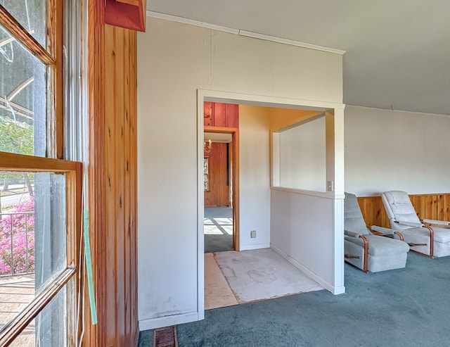 interior space featuring ornamental molding, light colored carpet, and wooden walls