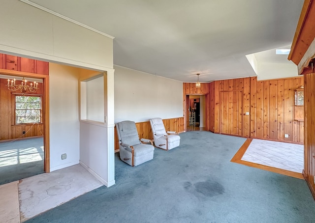 unfurnished living room with wood walls, carpet floors, and an inviting chandelier