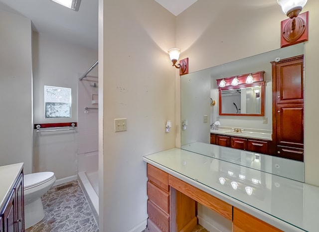 bathroom featuring vanity, toilet, and walk in shower